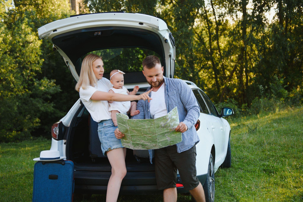 молодая семья в белой одежде у открытого багажника
