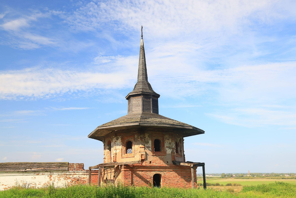 поле с небольшой старинной постройкой