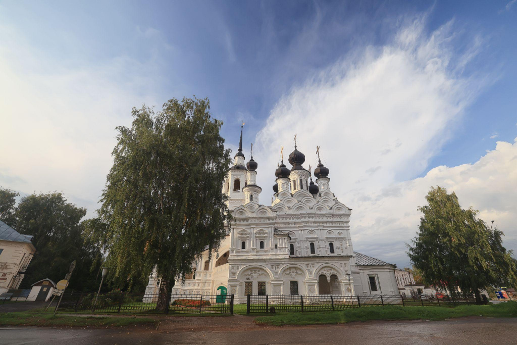 белокаменная церковь за черным забором